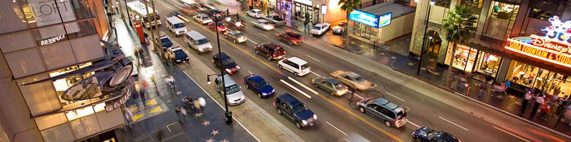 A busy city street scene with cars, buildings, palm trees, and sidewalk stars suggests a popular tourist area, likely Hollywood Boulevard, ending the sentence.