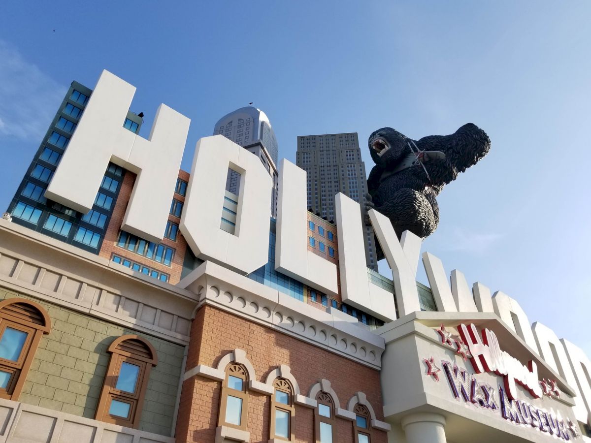 A large sign reads "HOLLYWOOD" with a giant gorilla statue climbing it, located atop a building with "Wiz Museum" signage.