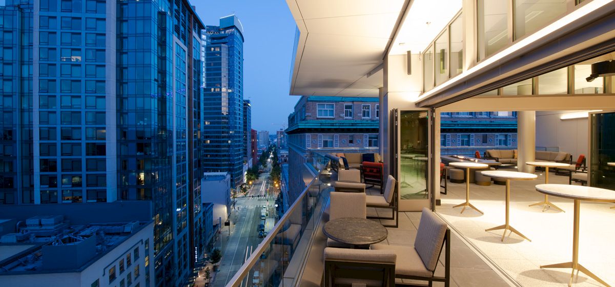 A balcony with a city view and outdoor seating area