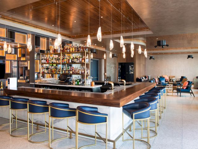 A bar with blue stools and a wooden countertop